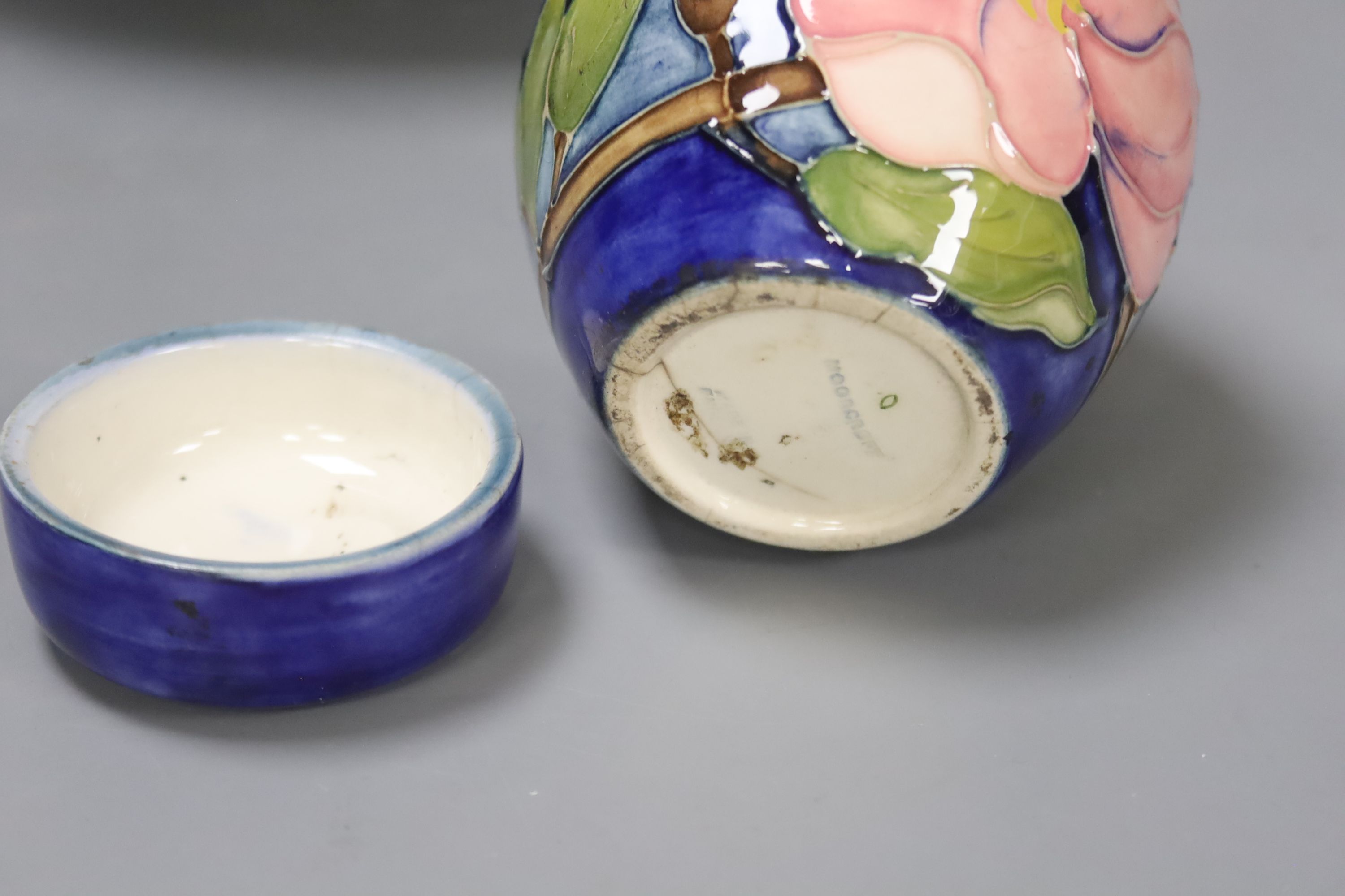 A pair of Moorcroft candlesticks, a jar and cover, and a bowl